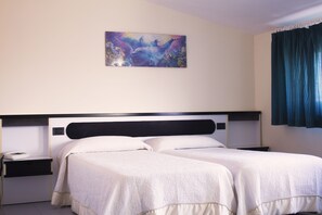 Quarto triplo básico, várias camas, para fumantes, vista para a cidade | Roupas de cama premium, escrivaninha, Wi-Fi de cortesia