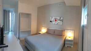 A modern bedroom with a bed, bedside tables, a painting on the wall, and a view of the hallway. - Crystal bed and breakfast (Dormelletto)