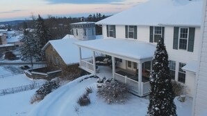 A snow-covered residential house with a porch and a chimney. - The Rosemont Inn (Montrose)