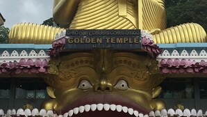 En stor gyllene Buddha-staty med inskriptionerna ”GULDEN TEMPEL” och ”Dambulla”.