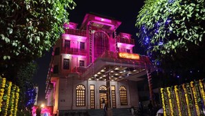 Un hôtel de style architectural traditionnel, doté de fenêtres en arc de cercle et d’un balcon.