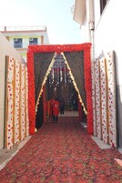 Une entrée agrémentée de compositions florales et recouverte d’un tapis à motifs.