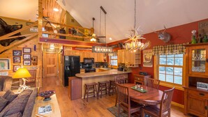 Un'ampia cucina con isola centrale, mobili in legno e zona pranzo con un grande tavolo e sedie.