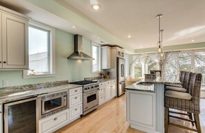 A spacious kitchen with a large island, built-in appliances, and a view to the outdoors. - Beachfront Luxury Home-NEW Private Heated Pool, Lake View, Firepit, Game Room (South Haven)
