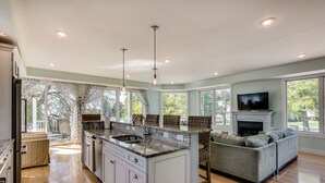 Una cocina amplia con una isla grande, una chimenea empotrada y una zona de estar acogedora con sofá y sillones.
