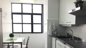 A compact kitchen with a dining table, chairs, a window, a sink, and an oven. - Wonderful Penthouse  (Funchal)