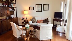 A living room with a sofa, armchairs, a coffee table, a TV, and a bookshelf. - Wonderful Penthouse  (Funchal)