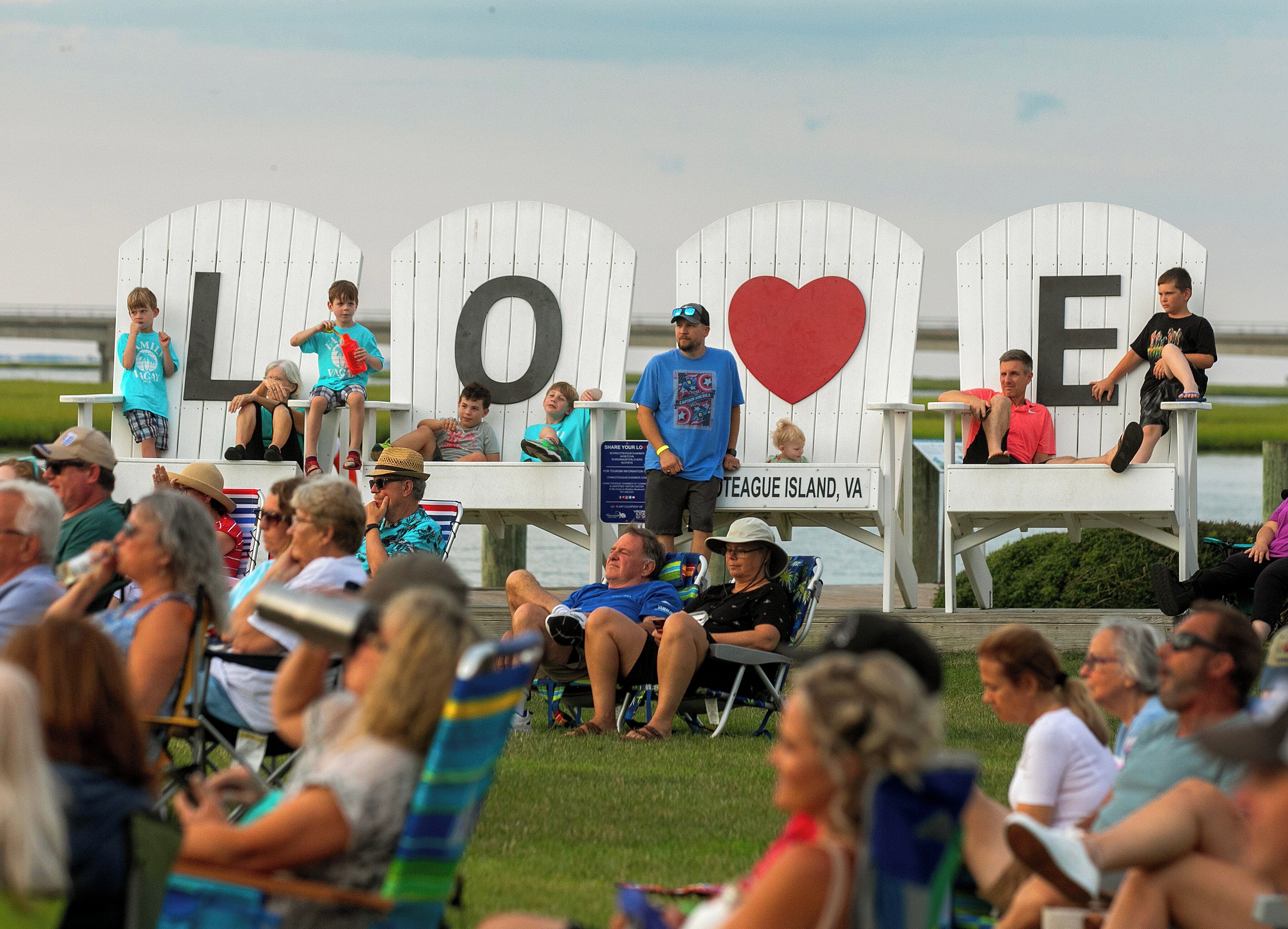 Una terraza con sillas Adirondack y un cartel que dice 'LOVE'.