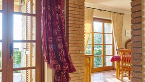 Une pièce dotée d’une arche en briques, d’une porte en bois et offrant une vue sur l’extérieur.