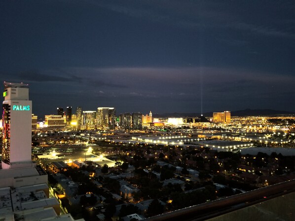 A nighttime cityscape with illuminated buildings and a prominent hotel sign.