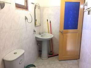 A bathroom with a sink, toilet, and a door. - Lake View Home Stay Tangalle (Tangalle)