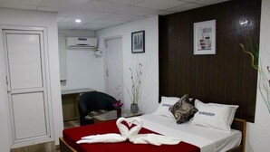A hotel room with a bed, a desk, and a chair. - Suradeep Residency (Tirukalukundram)