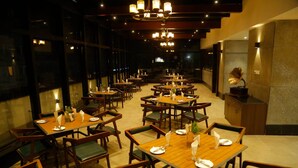 A restaurant with multiple tables and chairs, each set with plates, cutlery, and glasses. - The Hamuse Hotel Kodaikanal - Luxury Redefined (Kodaikanal)