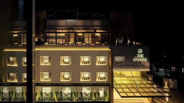 A modern hotel with a prominent entrance, multiple floors, and a well-lit facade. - The Hamuse Hotel Kodaikanal - Luxury Redefined (Kodaikanal)