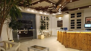 Un interior moderno con una barra de madera, zona de estar y mostrador de recepción.