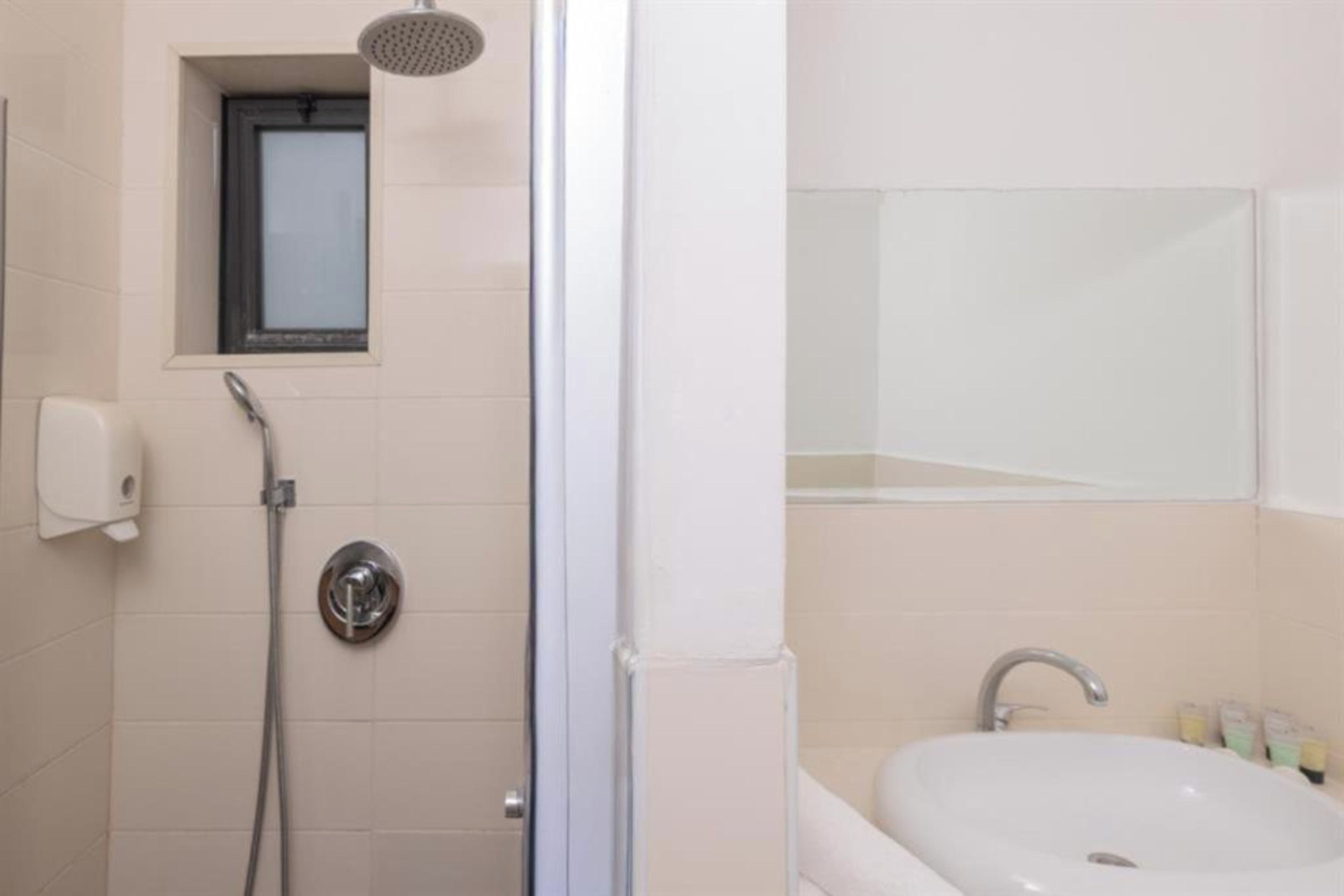 A bathroom with a shower, a sink, and a mirror.
