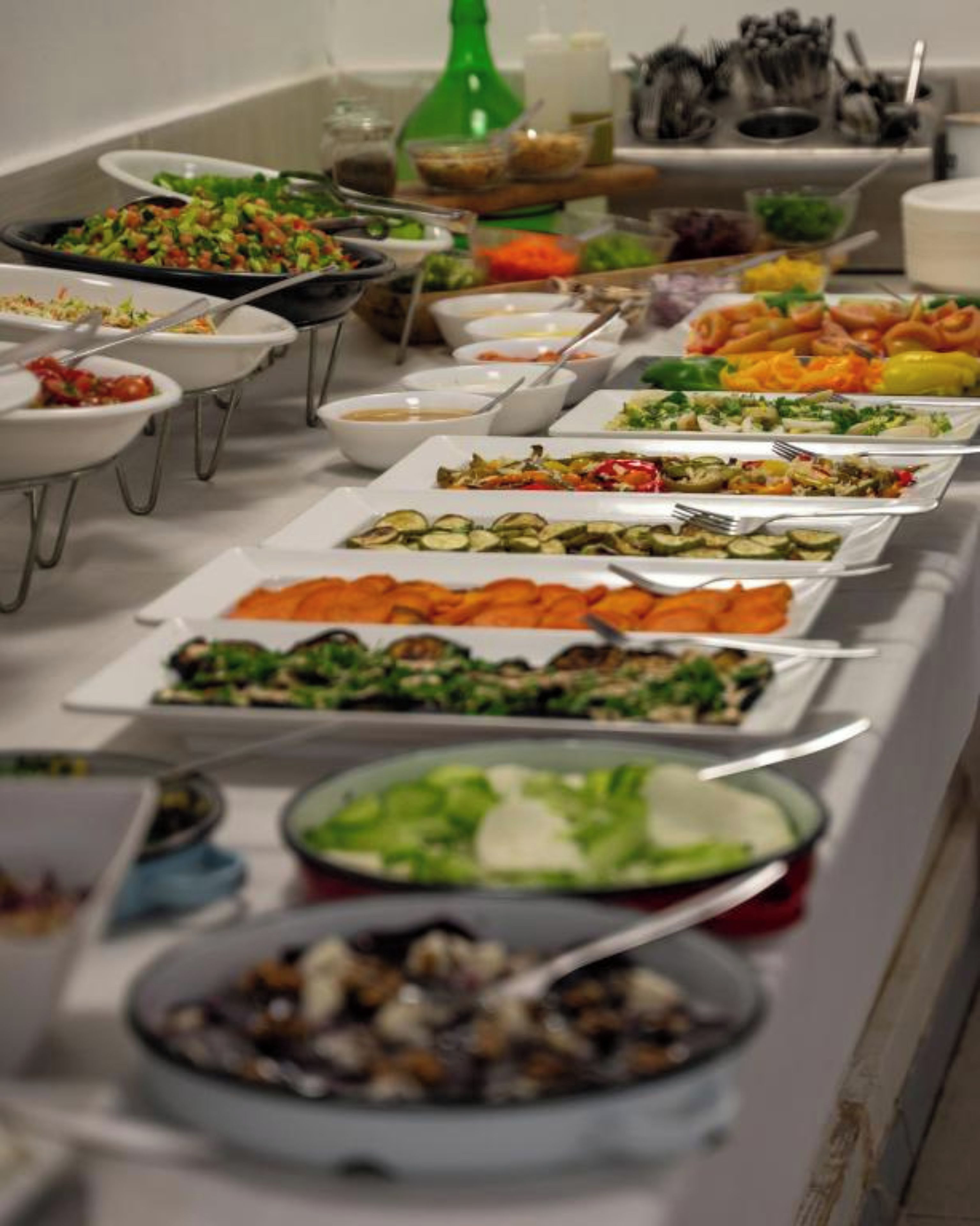 Une table de buffet avec divers plats et ustensiles.