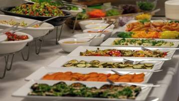 Une table de buffet avec divers plats et ustensiles.