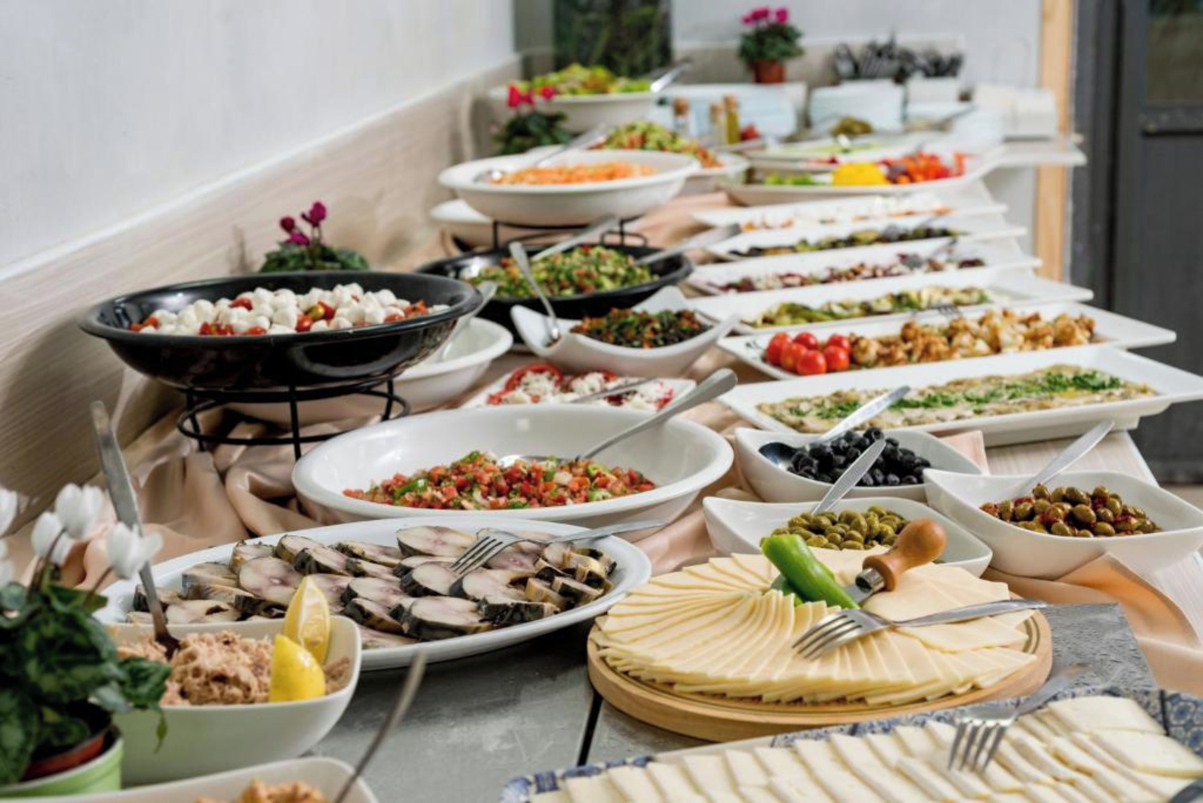 A buffet with various dishes and a cheese board.