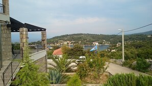 A view of a hillside with a building featuring a stone facade and a balcony. - Holiday Home Kaic (Solta)