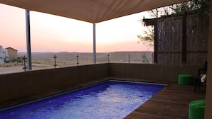A swimming pool with a wooden deck and a view of the desert landscape. - Nahal Faran 32 (Ramat Negev)