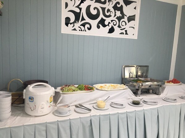 A buffet setup with various food items, a coffee maker, and a decorative wall panel. - Sky Cottage (Rayong)