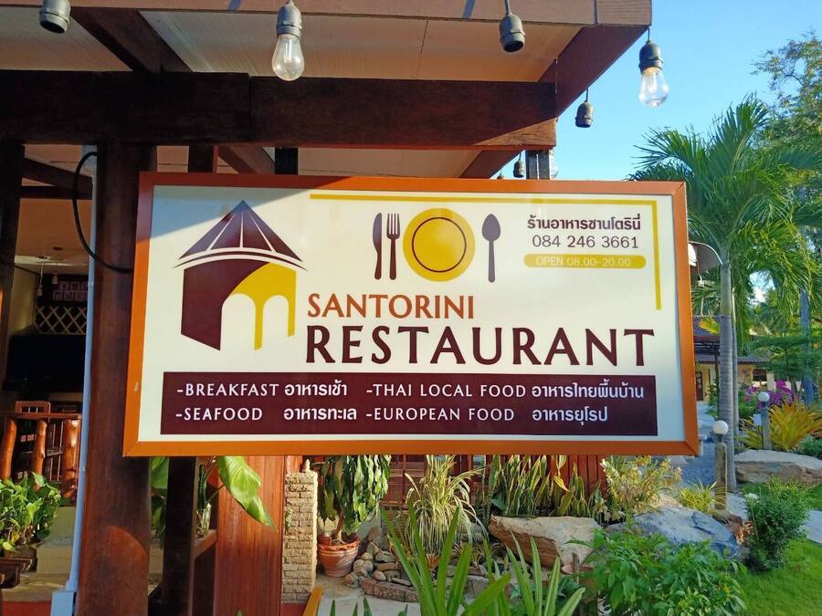 A restaurant signboard with the name 'Santorini Restaurant' and mentions breakfast, seafood, and European food.