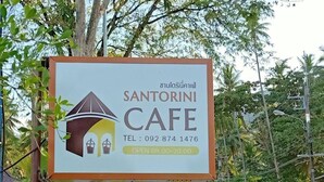A sign for Santorini Cafe with a contact number and operating hours. - Santorini Khanom (Khanom)
