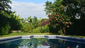 Una piscina al aire libre, sillones reclinables de piscina