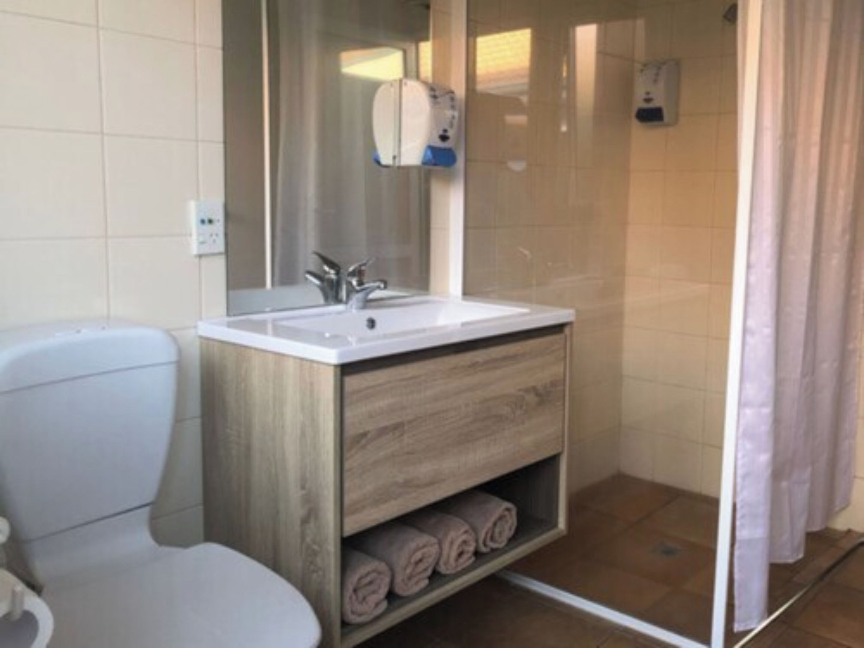 Un baño con inodoro, lavamanos y ducha.
