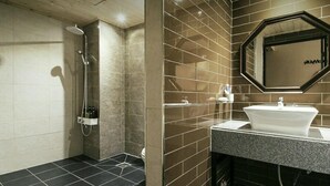 A modern bathroom with a shower, a sink, and a mirror. - The Hotel Changwon (Changwon)