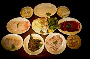 Une variété de plats présentés sur des assiettes, comprenant des fruits de mer, de la viande et des légumes.
