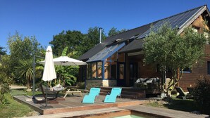 A swimming pool with two lounge chairs and a patio umbrella. - LE CABANON BRETON - Ecogîte with SWIMMING POOL near SAINT-MALO, MONT-ST-MICHEL (Saint-Pierre-De-Plesguen)