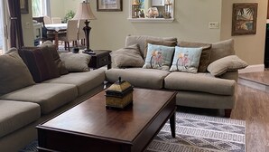 Un salon avec un canapé d’angle, une table basse et un tapis à motifs.