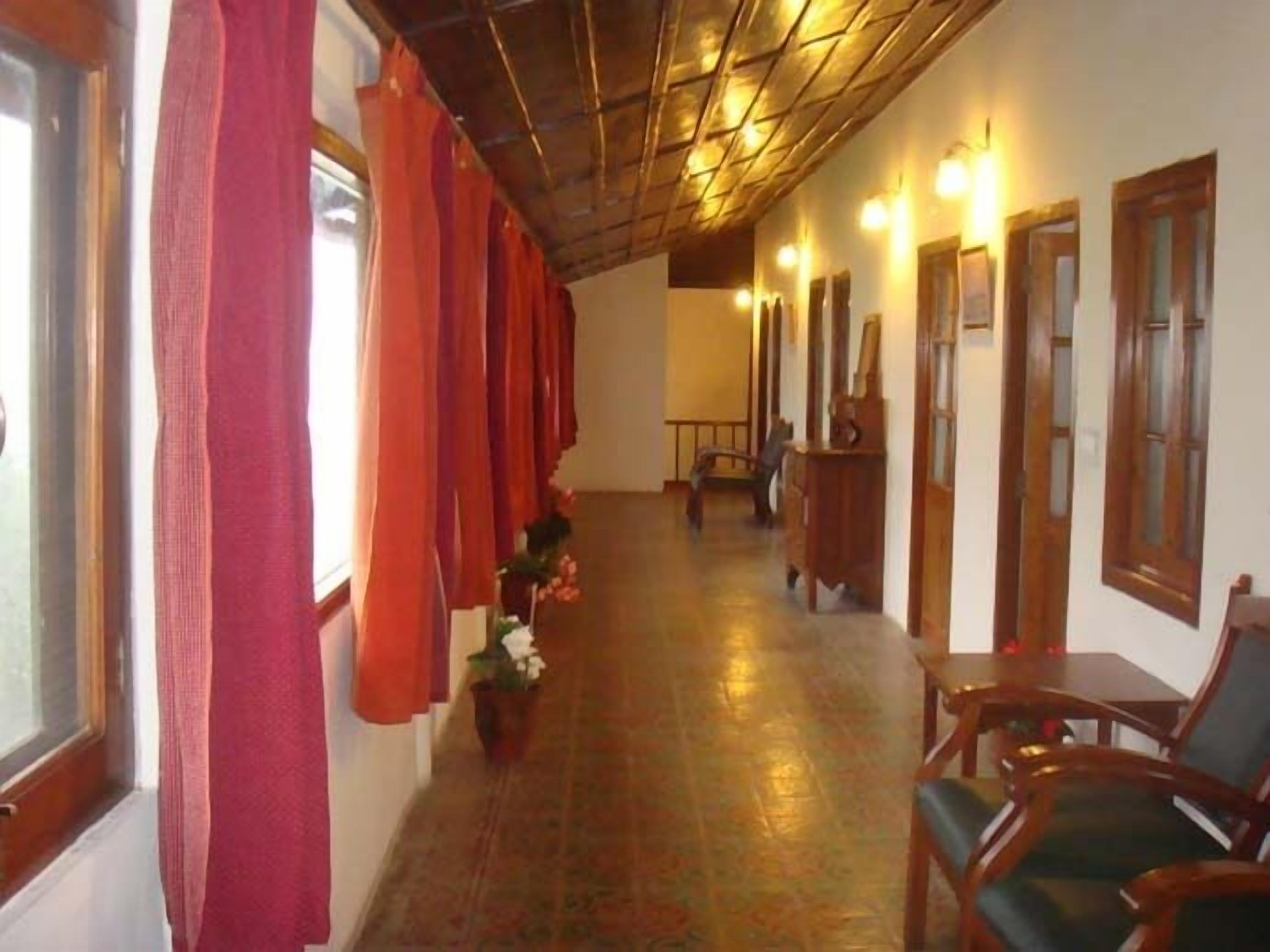 A corridor with wooden doors, a wooden bench, and a potted plant.