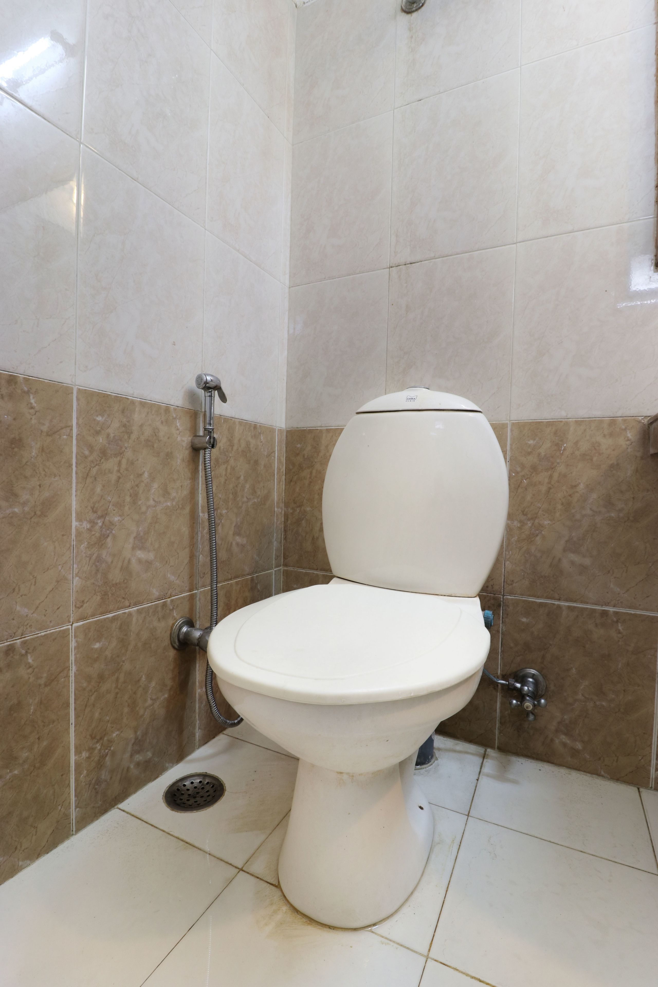 Une salle de bain équipée de toilettes, d’une douche et d’un drain.