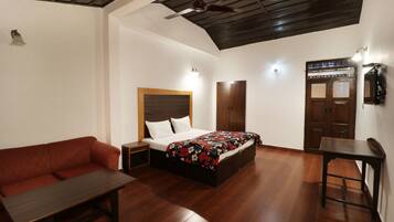 Un dormitorio con cama, banca de madera, mesita de noche, armario y mesa.