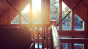 A wooden cabin with a staircase leading to a balcony. - Cozy knotty pine chalet with creekside deck, BBQ, and access to pools, hot tubs, gym, golf, hiking. (Redmond)