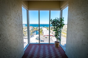 A balcony with a potted plant, a view of the sea, and a tiled floor. - Amazing Beach & Sunset Views, Free Lazy Days Beach Chairs/Umbrella provided (Pensacola Beach)