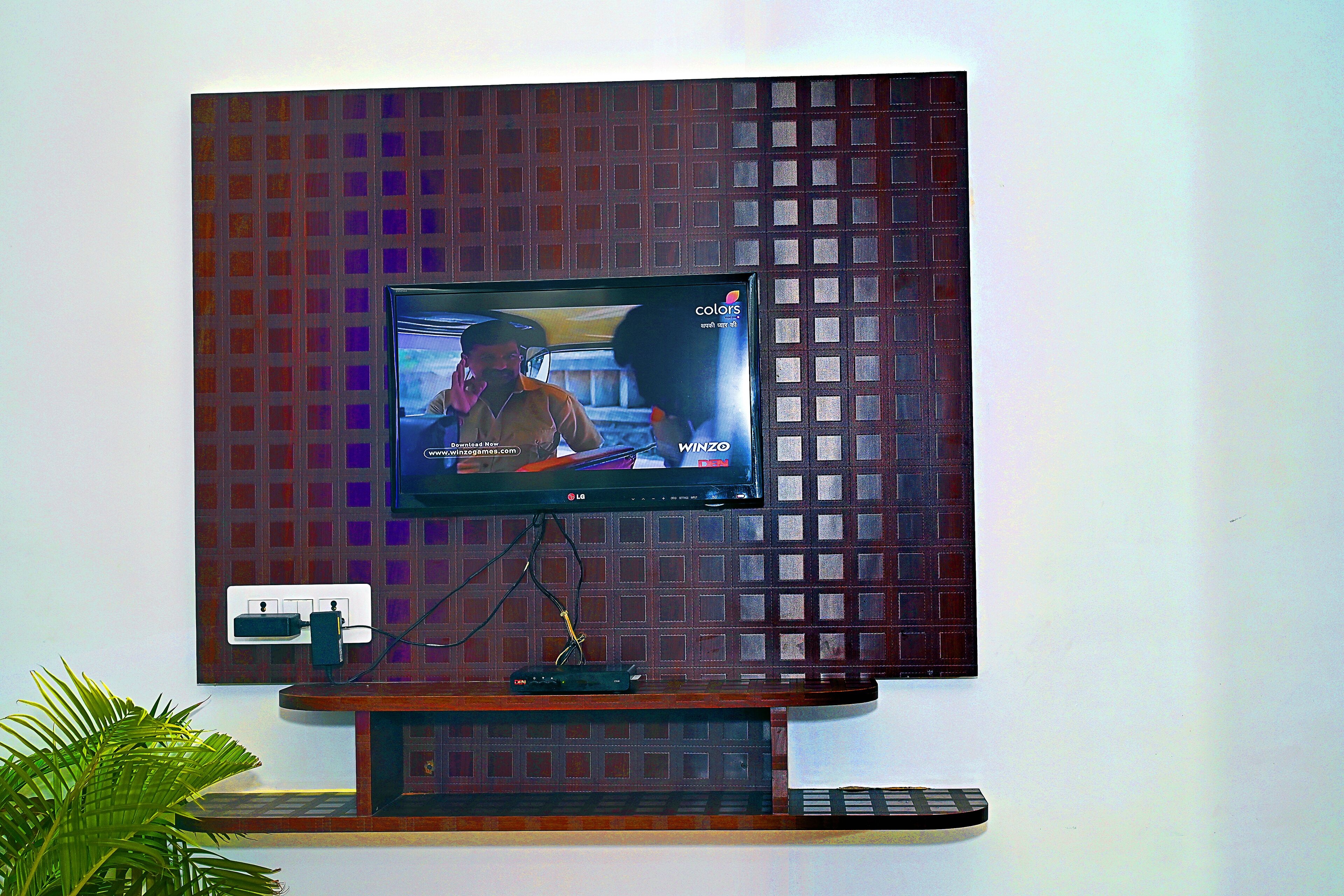 Ein Flachbildfernseher an einer Wand mit Holzausschlag.