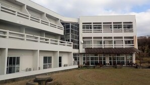 Un bâtiment moderne doté d’un toit plat, de grandes fenêtres et d’une cour avec des espaces de détente en plein air.