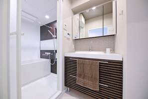 Eenvoudige tweepersoonskamer | Badkamer | Een bad/douchecombinatie, gratis toiletartikelen, een haardroger