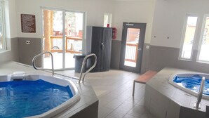 Ett hotellrum med en stor inomhuspool, en bänk och en dörr som leder ut.