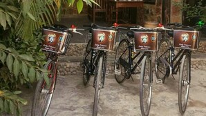 Trois vélos sont garés devant un immeuble à la façade en pierre, et chacun porte une enseigne indiquant « Lady Princess Motel ».