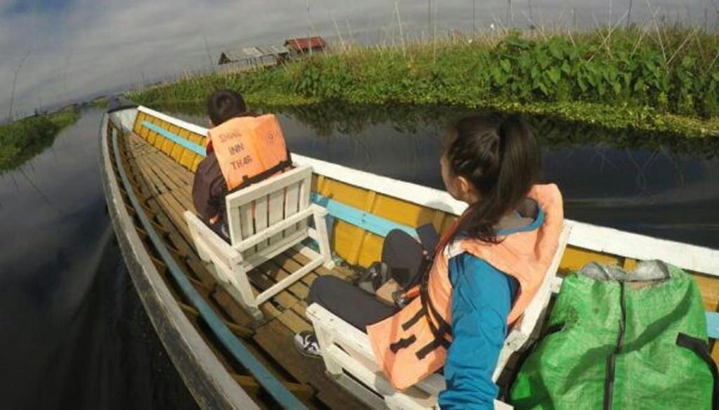 Una embarcación estrecha con pasajeros que llevan chalecos salvavidas, indicando una medida de seguridad para actividades acuáticas.