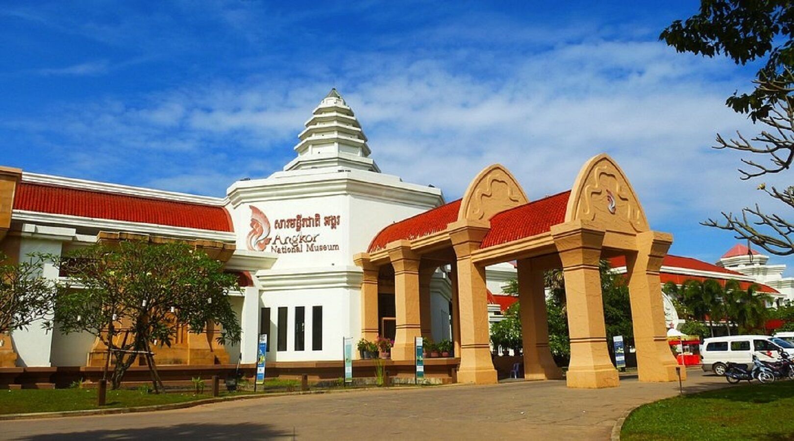 The entrance to the Angkor National Museum with a prominent white building and a traditional Khmer-style gate.