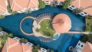 An aerial view of a resort with a central circular pool, surrounding lounge areas, and multiple buildings with red-tiled roofs. - Memoire Palace Resort & Spa (Siem Reap)