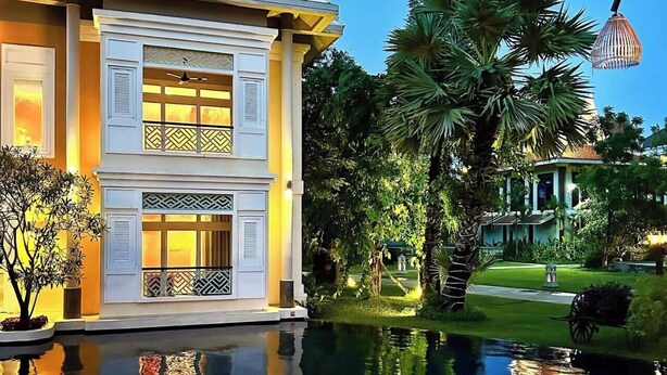 A two-story building with a pool, surrounded by lush greenery and palm trees. - Memoire Palace Resort & Spa (Siem Reap)