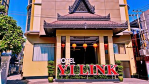 Un hotel con fachada moderna, entrada tradicional con techo de azulejos y un letrero grande que muestra el nombre 'YILINK'.