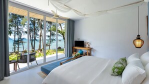 A bedroom with a large bed, a desk, and a view of the ocean. - Krabi Home Resort (Krabi)